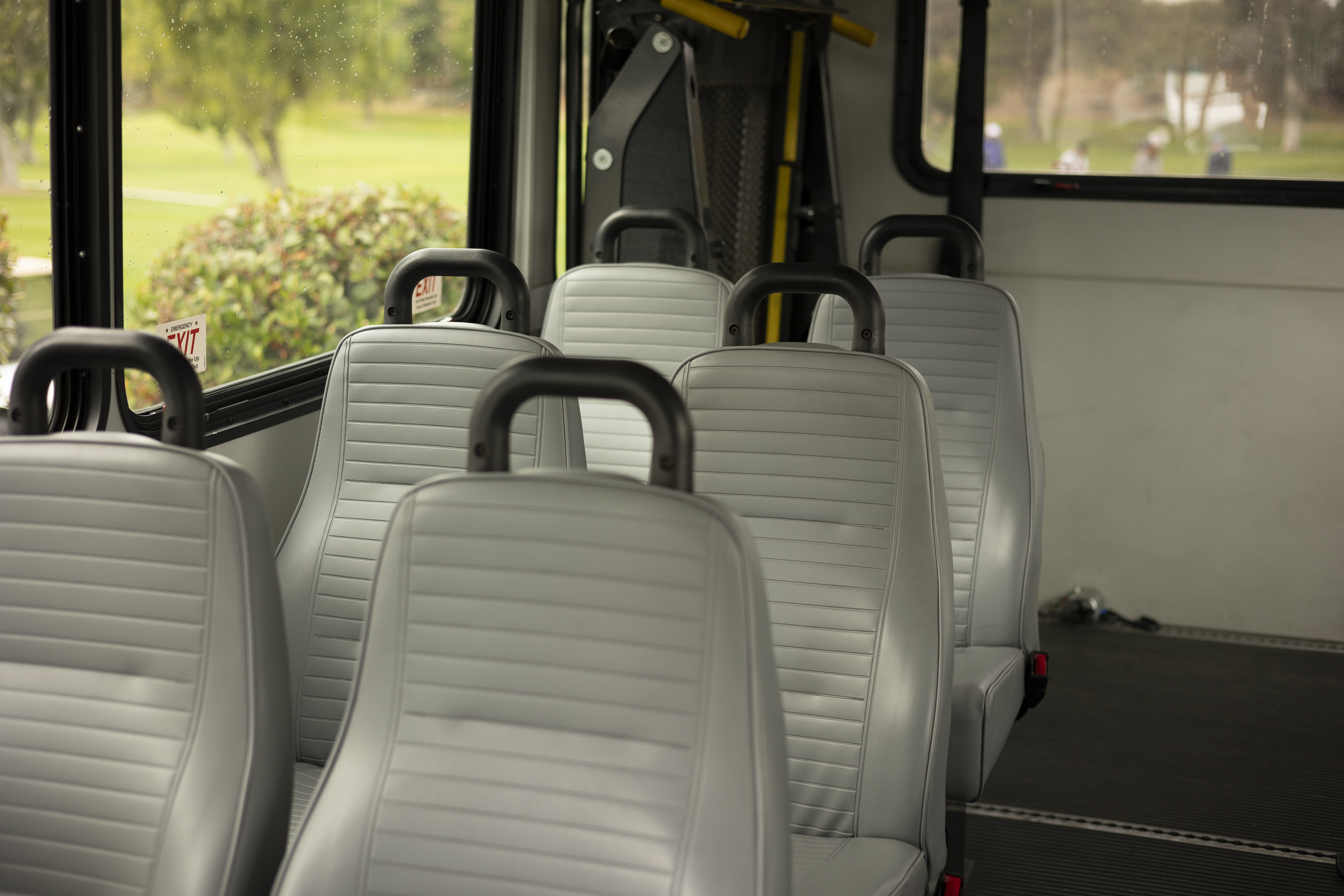 Three rows of two seats are shown in the back of a Ford E-350 cutaway with mobility van upfits.